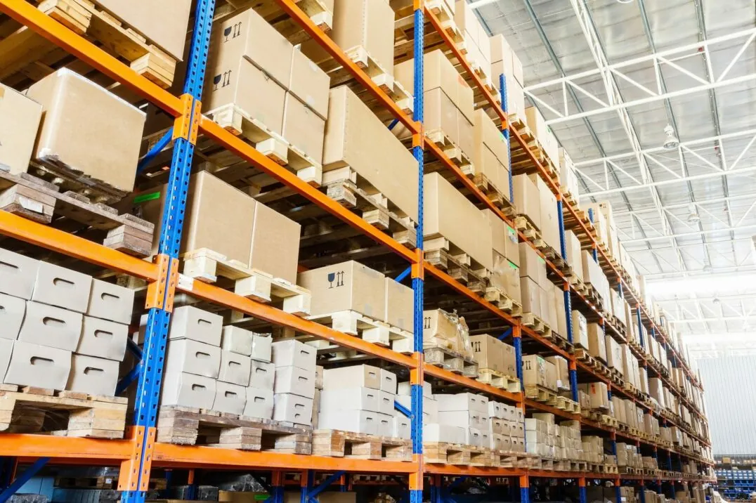 Image of a warehouse with high shelves full of stacked boxes; valantic Smart Industries & Industrie 4.0