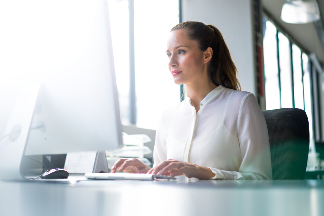 Businesswoman using computer at desk in office
