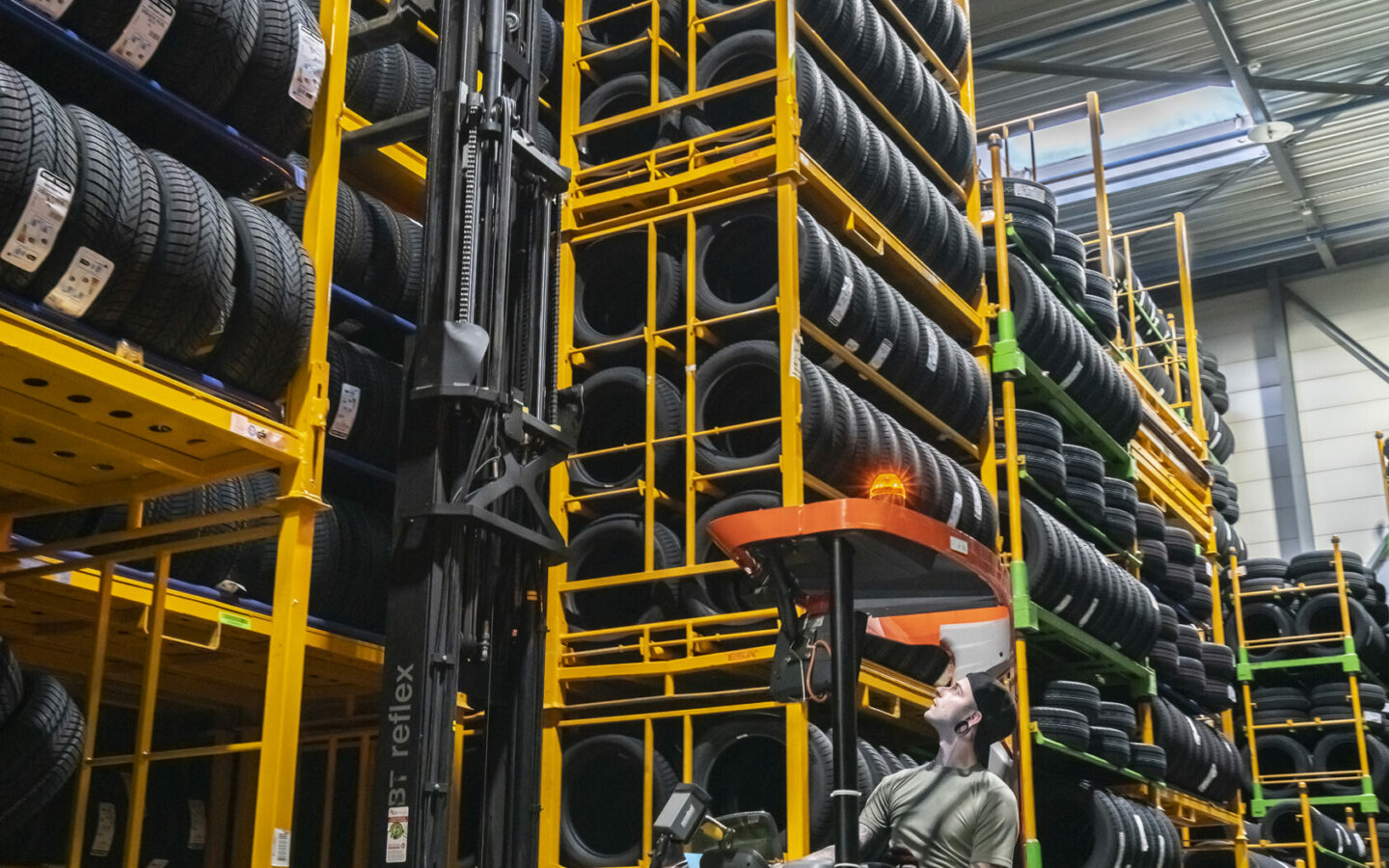 Image of a forklift operator lifting car tires onto racks.
