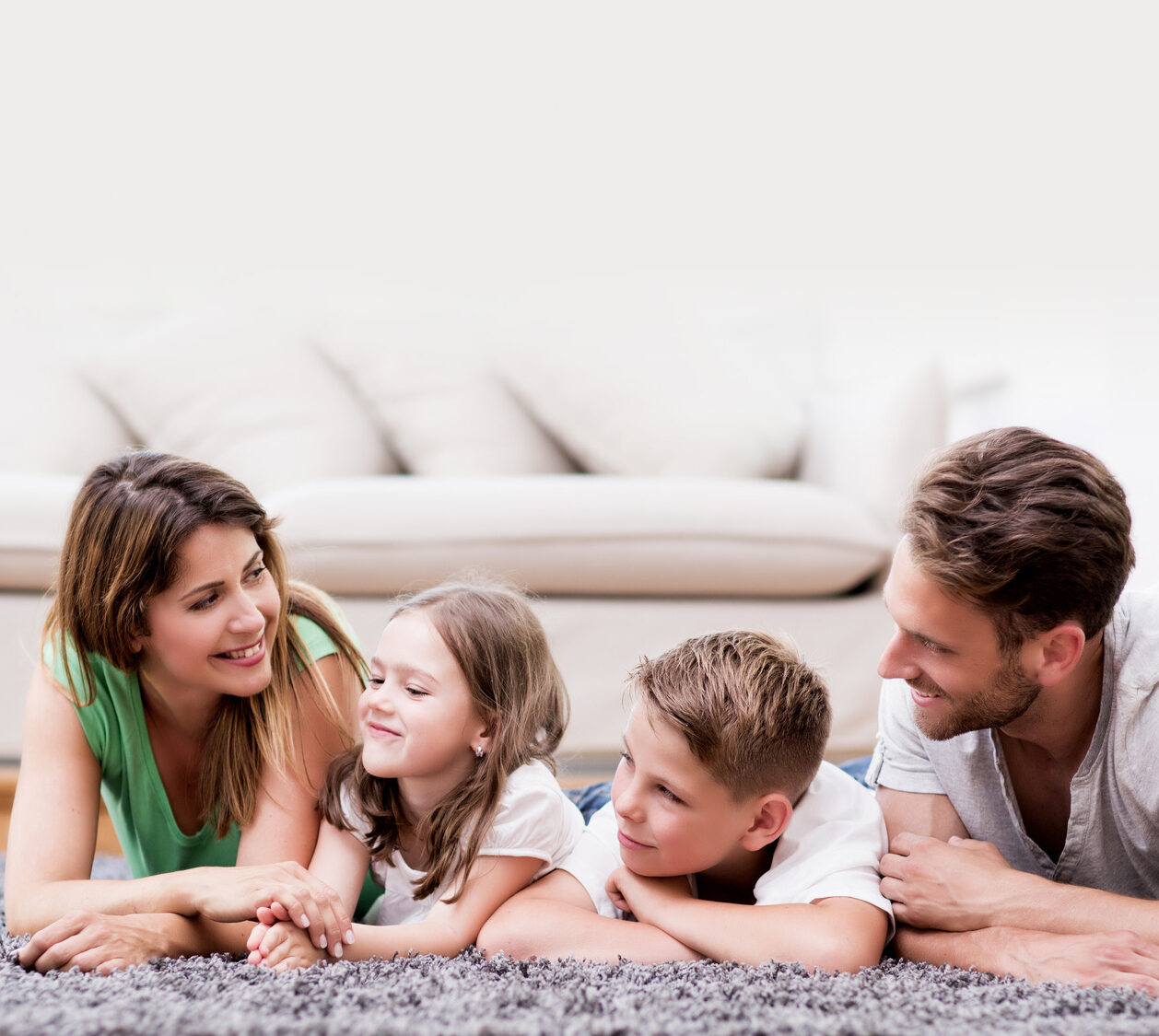Image of a couple and their two children on a fluffy carpet.