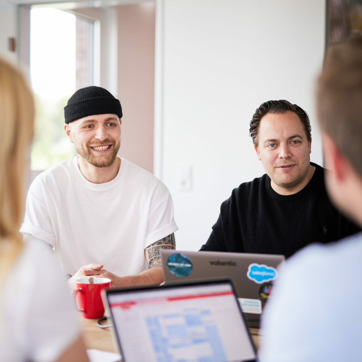 Foto von zwei Männern, die mit zwei Kunden in einem Meetingraum eine Besprechung durchführen.