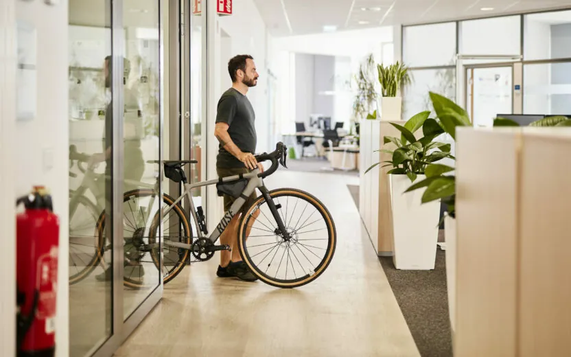 Ein valantic CX-Mitarbeiter, der sein Fahrrad aus dem Büro schiebt.