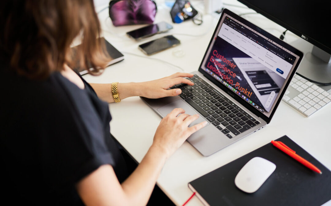 Eine weibliche Person arbeitet an einem Laptop . Auf dem Bildschirm ist ein valantic CX Projekt angedeutet.