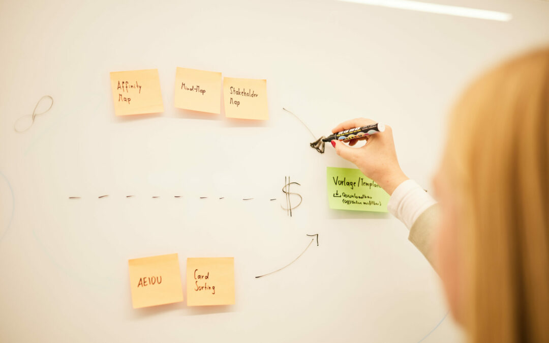 Eine Frau und ein Mann, die beide an einem Laptop arbeiten.