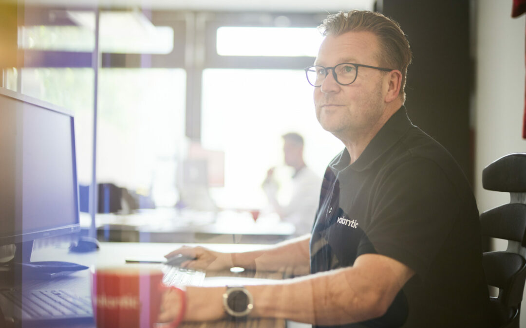 Man with glasses working on a computer.