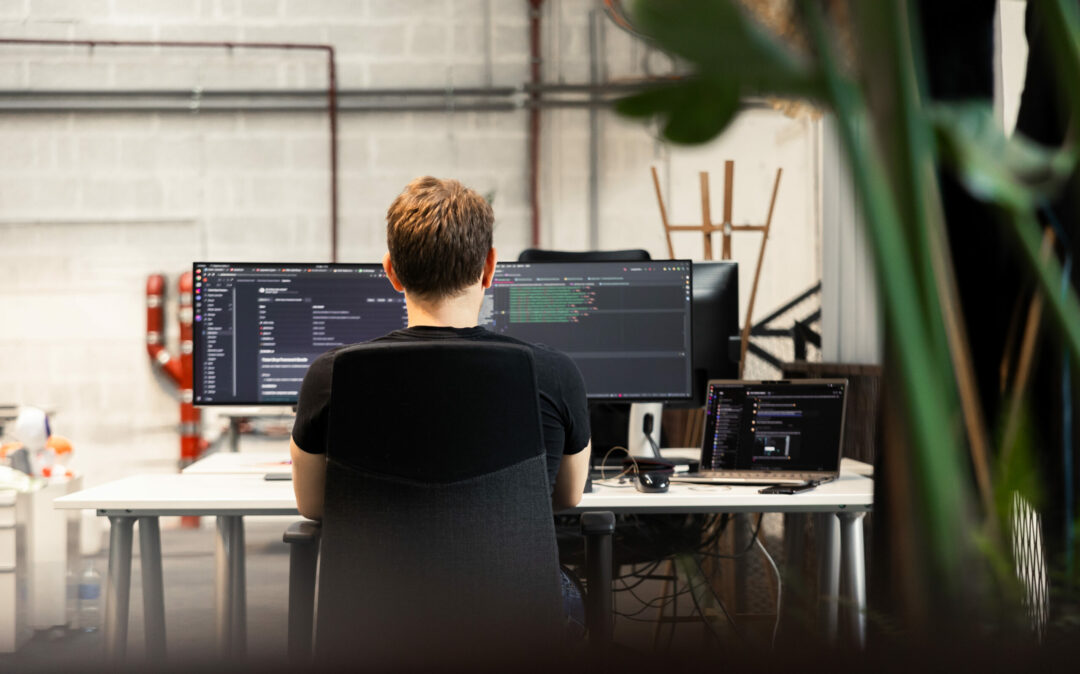 Eine rothaarige Frau reich während einer Präsentation dem Vortragenden ein Post-it