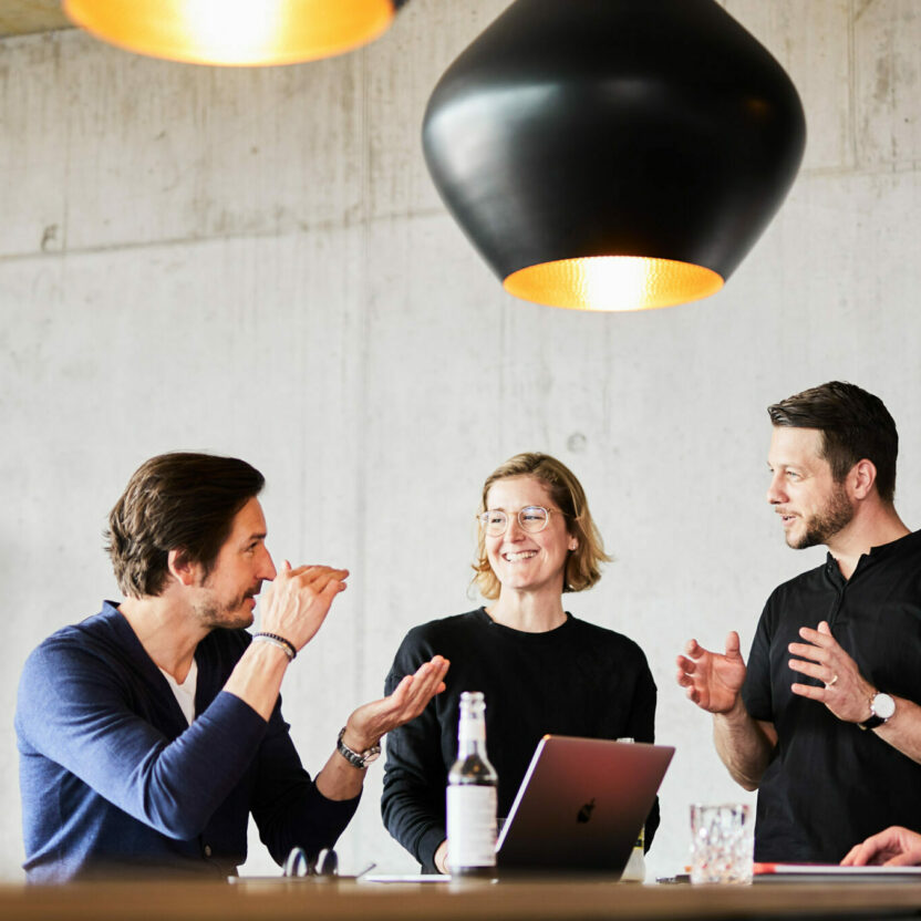 Photo of a team meeting at a standing desk.