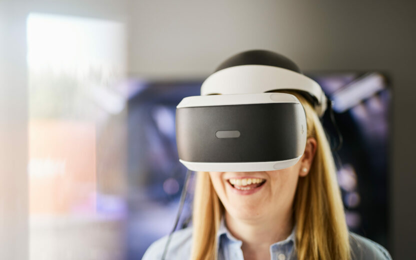 Photo of happy woman wearing VR glasses.