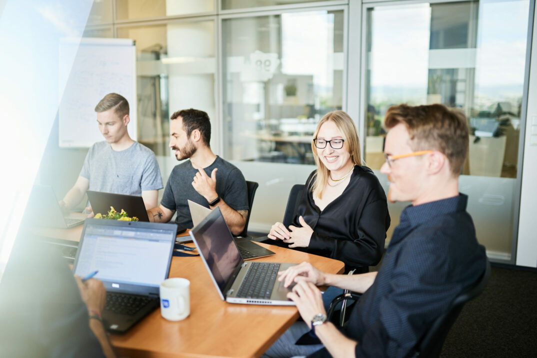 Foto von vier Personen während eines Business-Meetings.