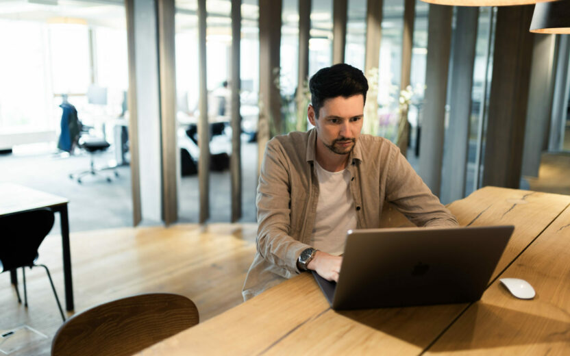Photo of a man working on his laptop at the office bar.