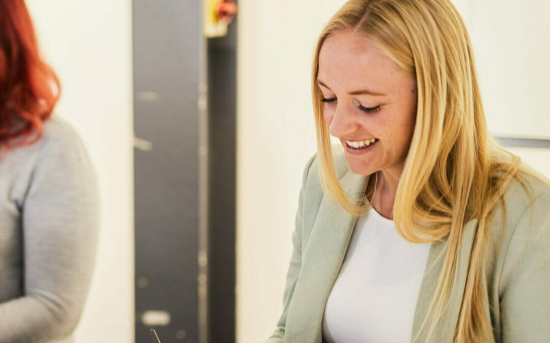 Photo of a woman taking notes during a meeting.