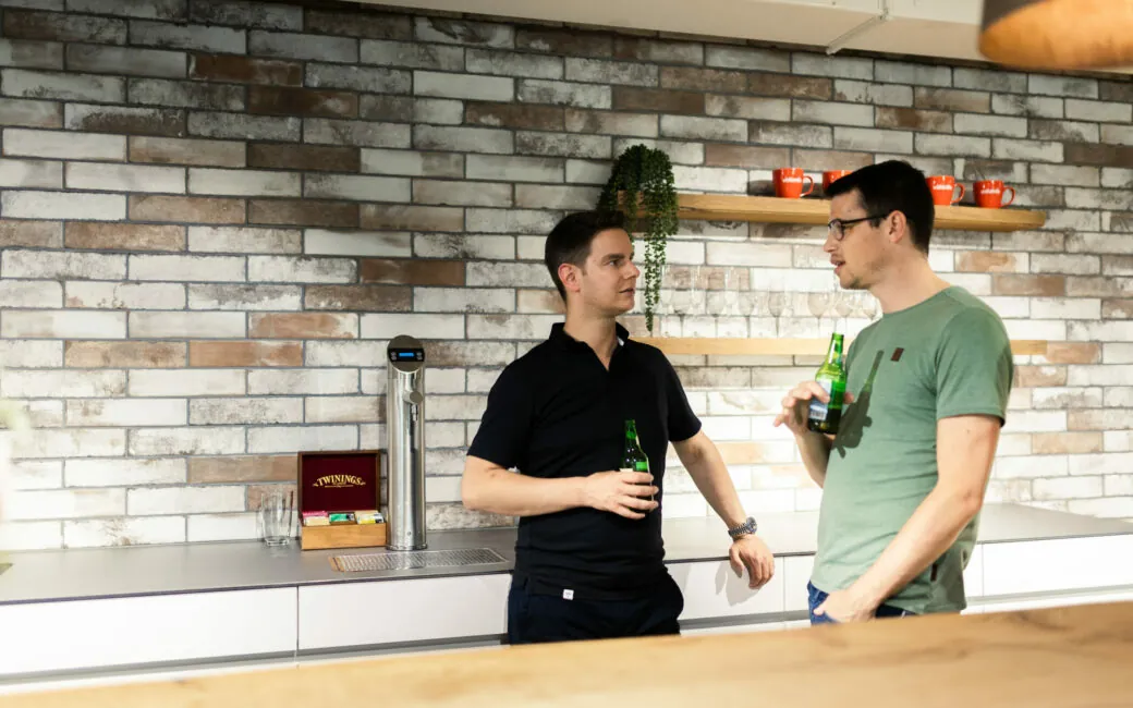 Bild von vier Kollegen die nach Feierabend mit Bier anstoßen.