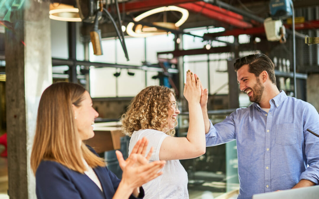 Photo of three colleagues celebrating a completed project.