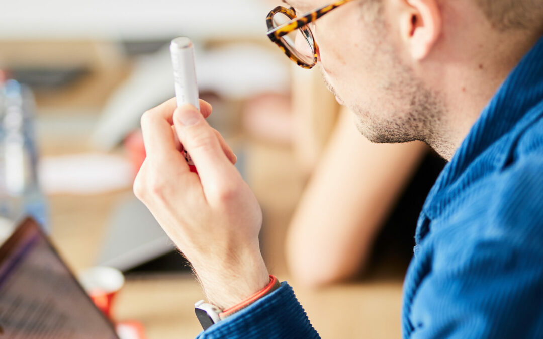Photo of a man sitting at his laptop – his face is not visible.