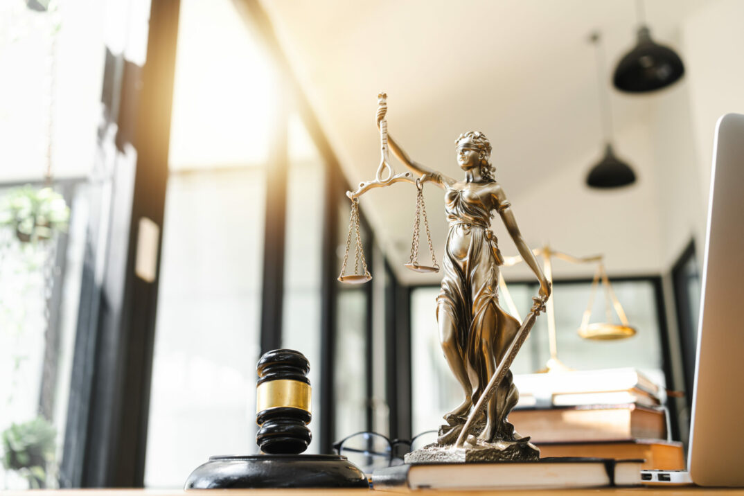 Statue des Justizia auf einem Schreibtisch; ESG - Governance