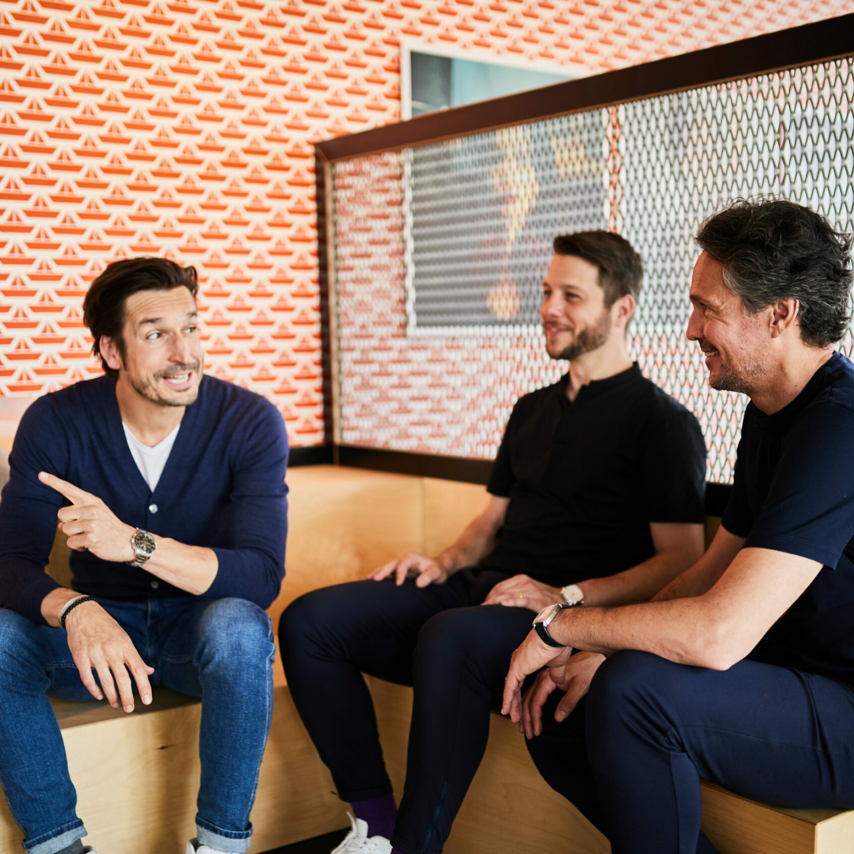 Bild von drei Kollegen der valantic CX, die sich auf einer Treppe sitzend über Customer Experience unterhalten.