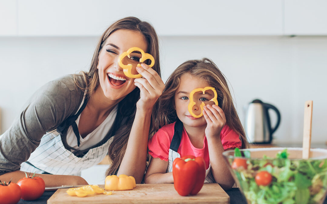 Bild von einer glücklichen Mutter mit Tochter die durch eine aufgeschnittene Paprika schauen, Omnichannel Plattform