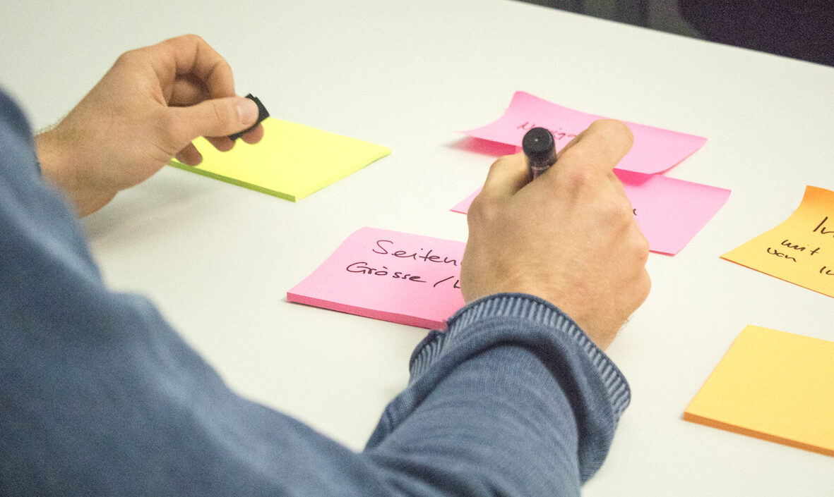 Picture of a person writing on Post-Its