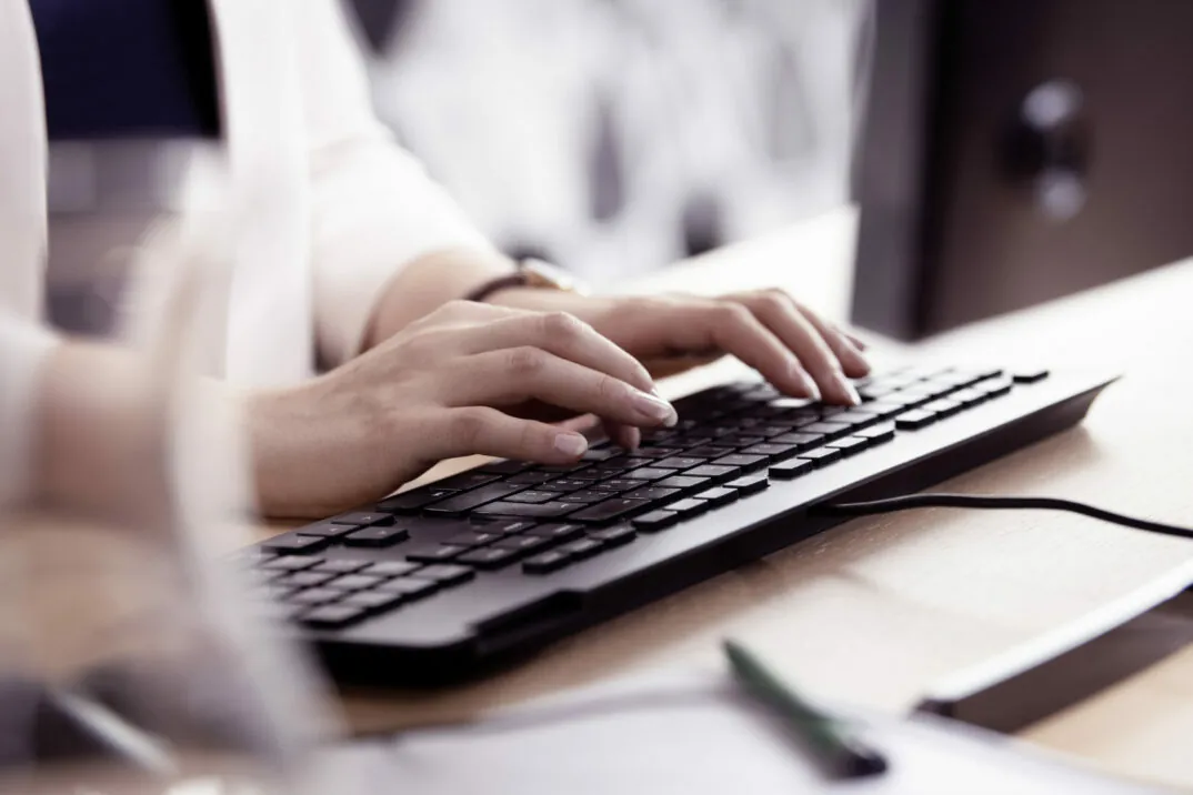 Tastatur auf Schreibtisch und tippende Hände - Helsana Success Story von valantic