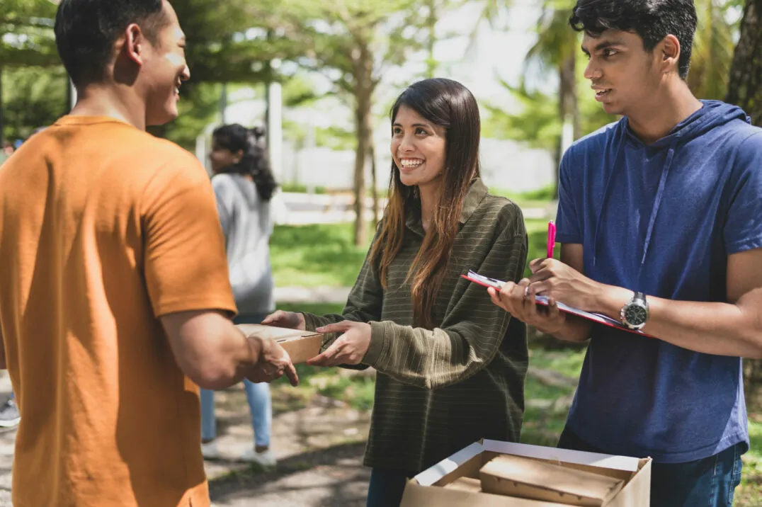 Volunteers hand over packages to those in need; ESG - Social