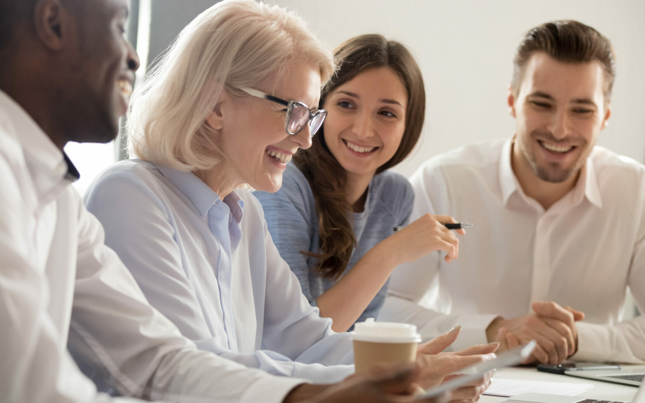 Geschäftsleute sitzen gemeinsam am Tisch und lachen