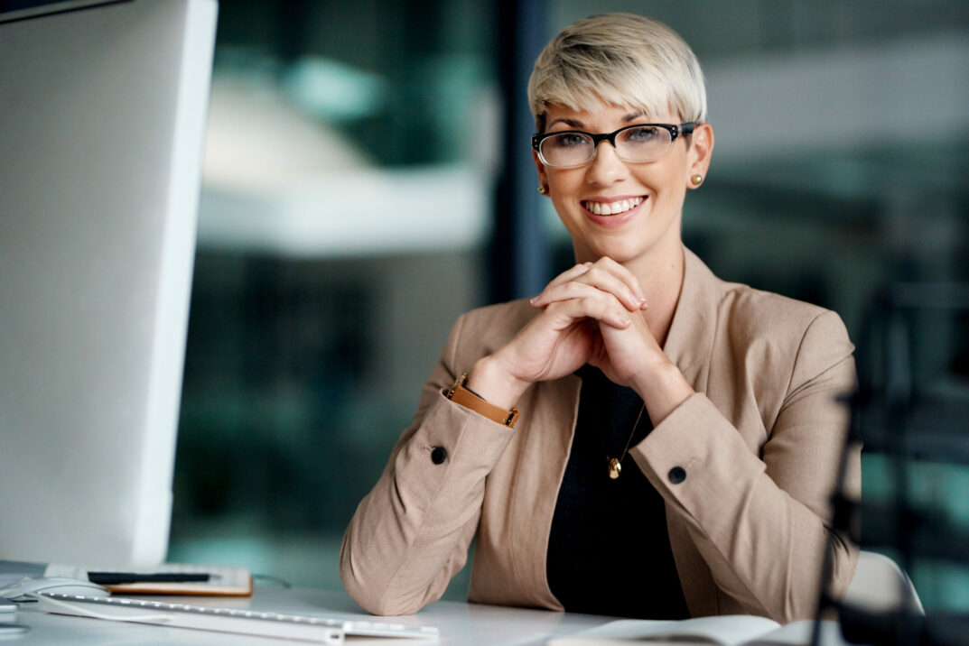 Bild von lächelnder Geschäftsfrau vor Laptop, valantic Personalakte bei Erste Group Bank