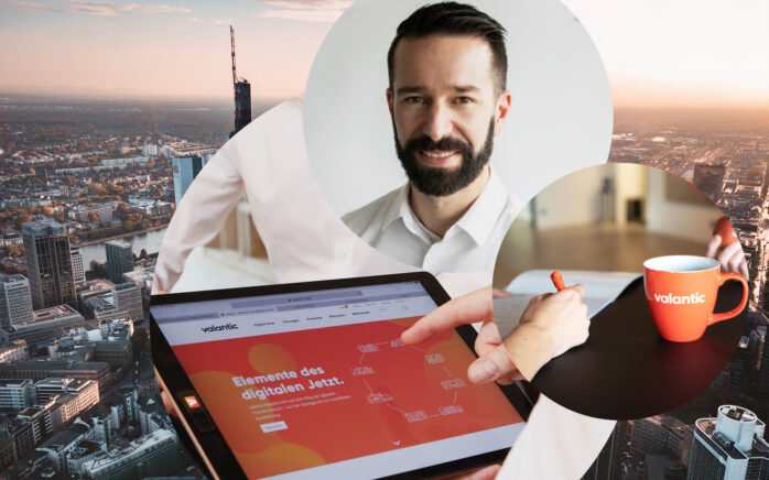 Portrait of Timo Rüb, Vice President at valantic, with a valantic mug and a tablet showing the home page of the valantic website, with the Frankfurt skyline in the background; The development of a digital future topic at valantic