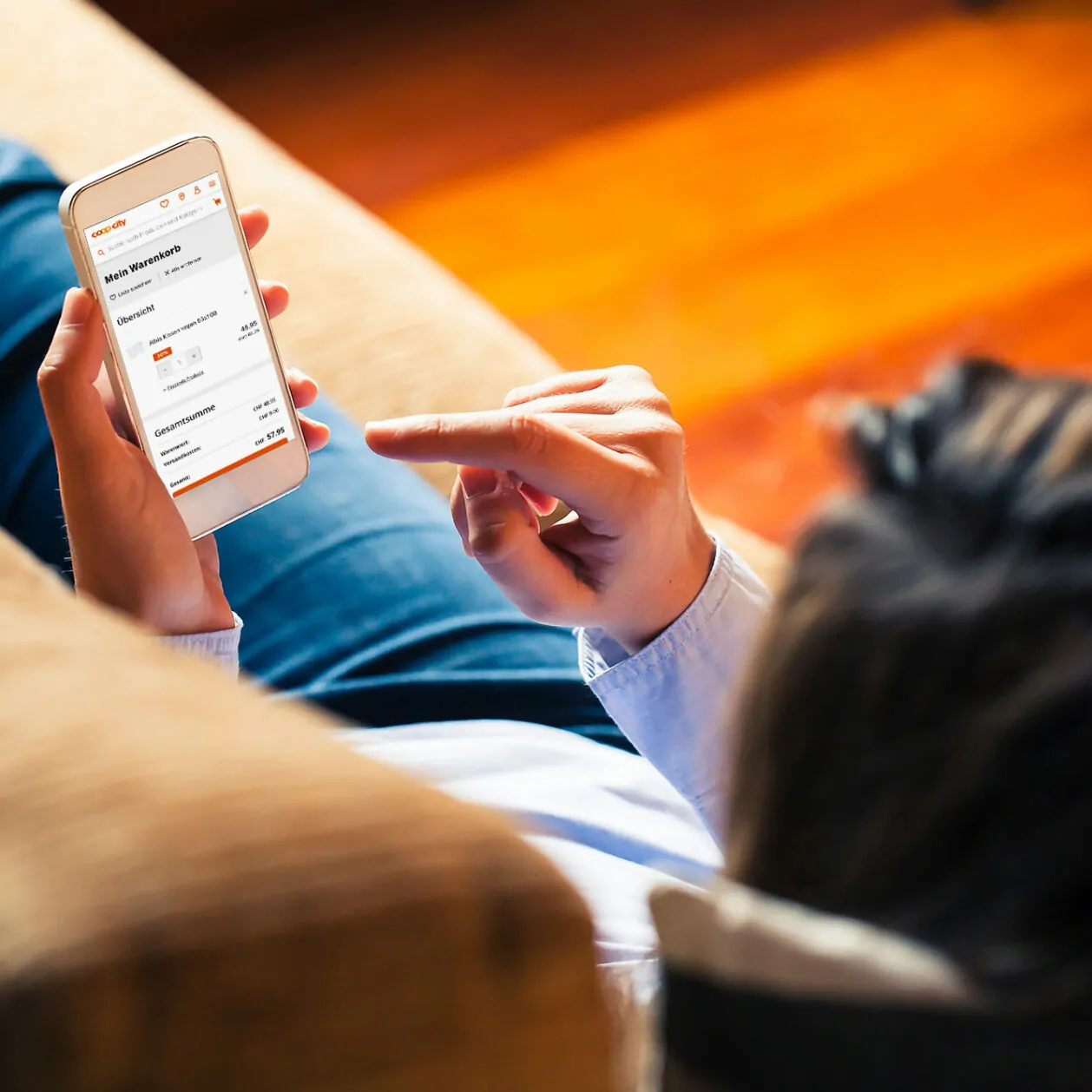 Image of a person lying down with a smartphone in the foreground, SAP Commerce