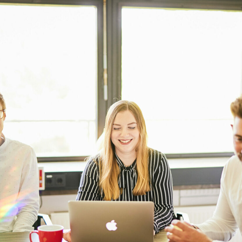 Foto von zwei glücklichen valantic-CX-Mitarbeitern, die an einer Teambesprechung zur Customer Experience teilnehmen.