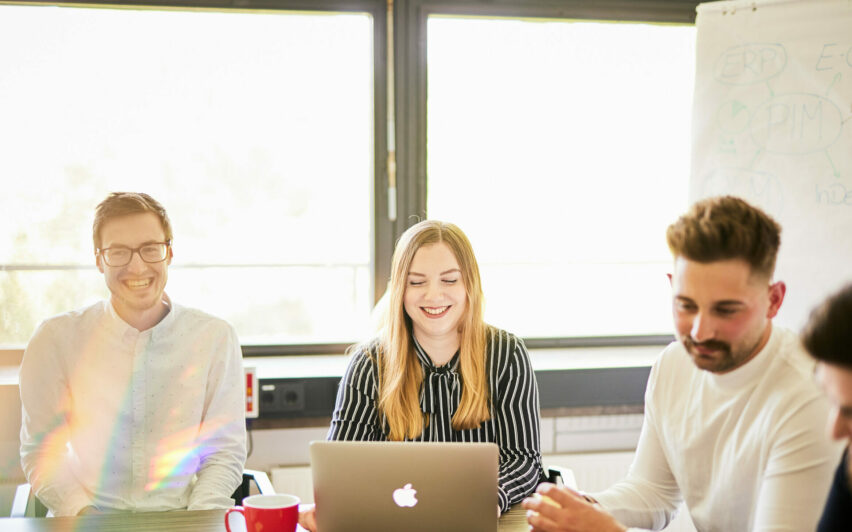 Photo of two happy valantic CX employees participating in a Customer Experience team meeting.