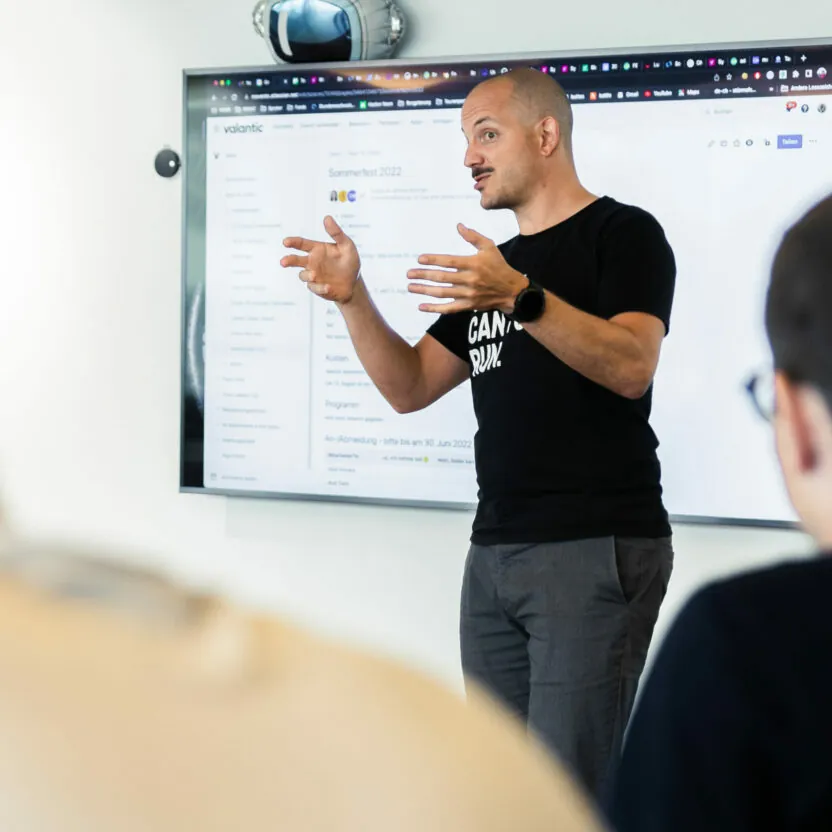 Photo of three valantic CX employees working on a customer experience presentation at a standing table.