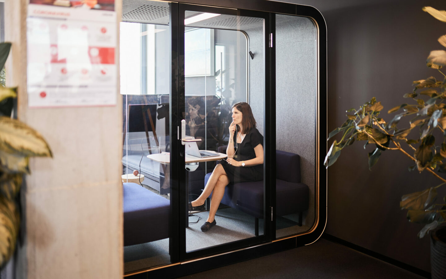 Foto von einer valantic-CX-Angestellten, die in einer Büro-Telefonzelle ein Telefonat über Customer Experience führt.