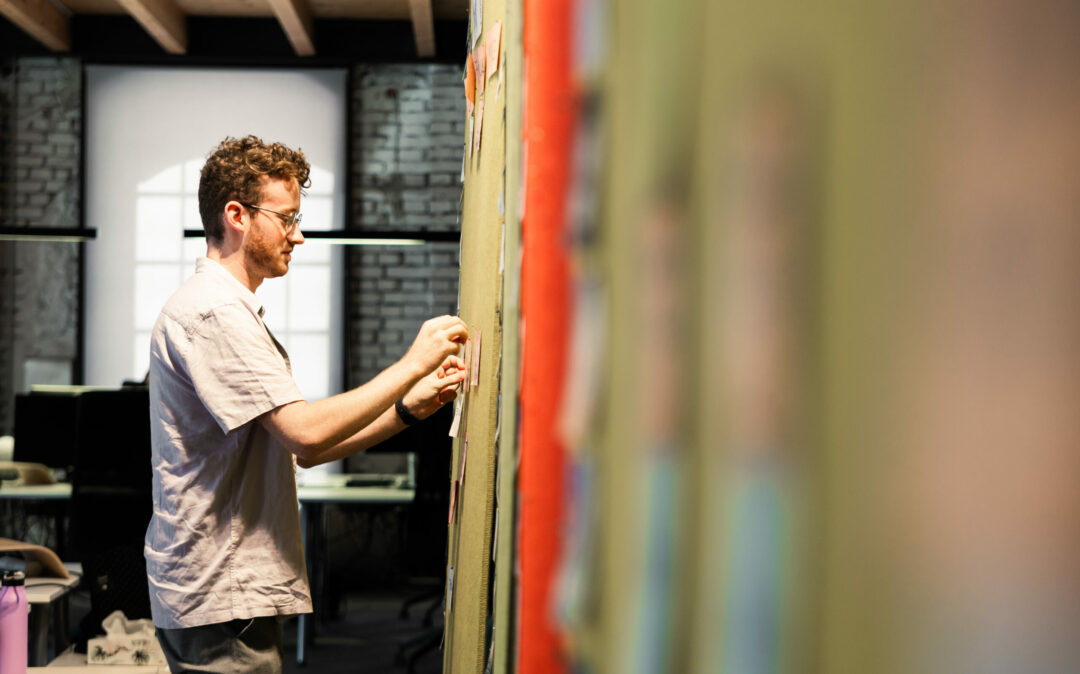 Photo of a young man presenting the latest customer journey data via PowerPoint in a meeting.