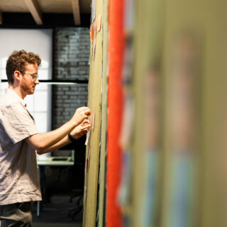 Photo of a young man presenting the latest customer journey data via PowerPoint in a meeting.