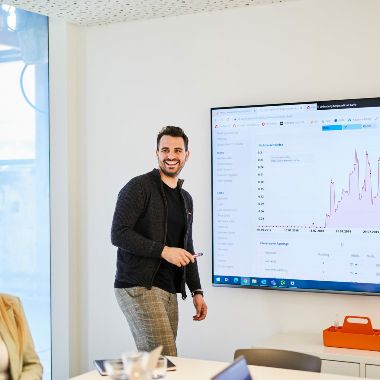 Photo of a young man presenting the latest customer journey data via PowerPoint in a meeting.