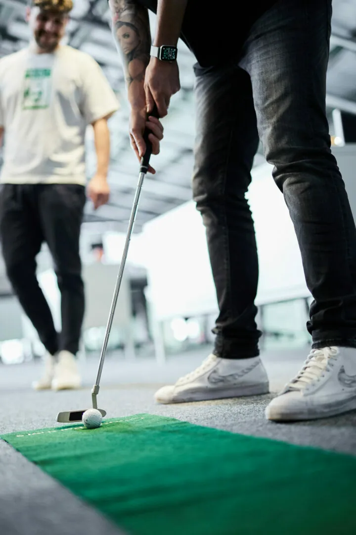Close-up of a valantic CX employee playing minigolf in the office during a break.