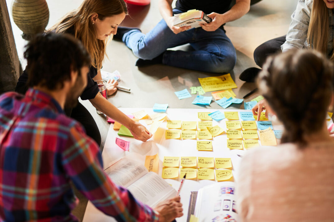Foto von einem valantic Team, das ein Plakat mit Post-its vorbereitet.