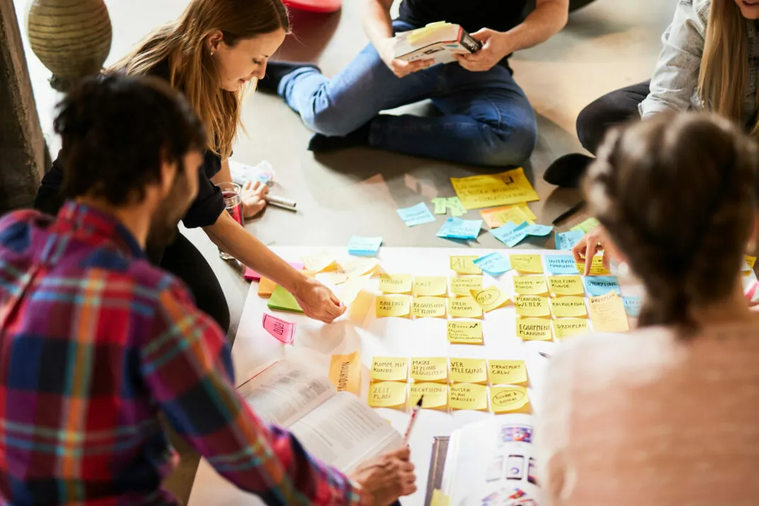 Foto von einem valantic Team, das ein Plakat mit Post-its vorbereitet.