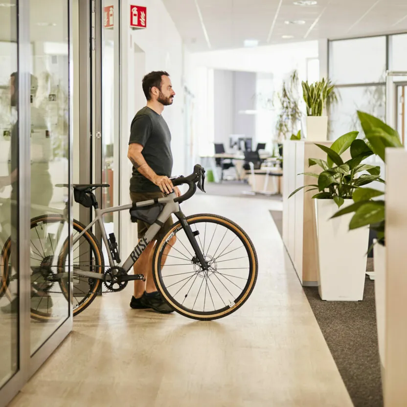 valantic CX employee pushing his bike out of the office.