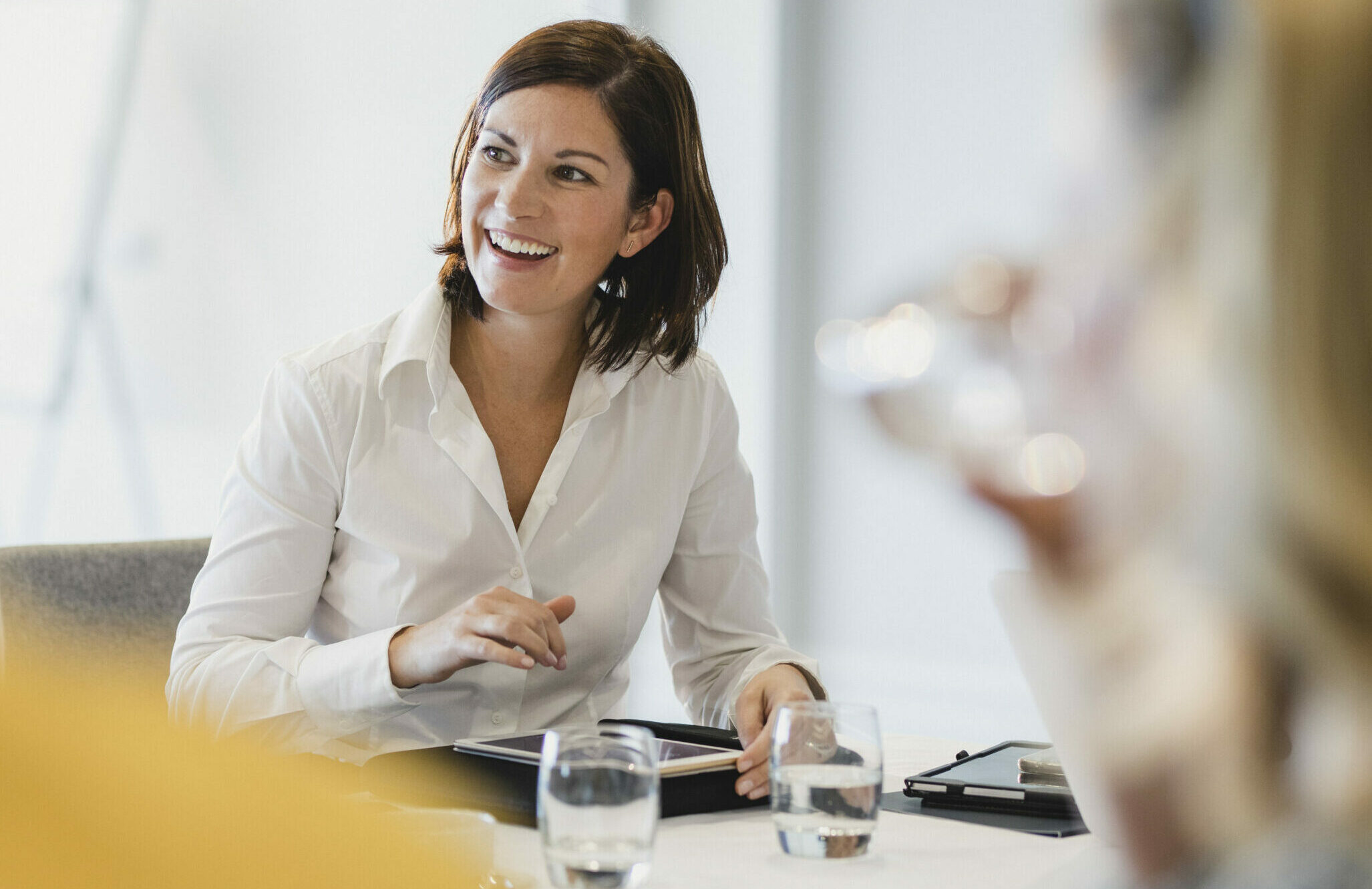 Lächelnde Geschäftsfrau im Meeting mit Tablet in der Hand | Rechtsakte in SAP