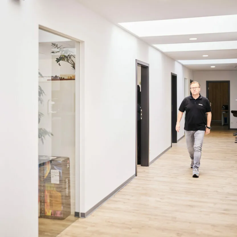 valantic Mitarbeiter läuft durch den Gang des valantic CX-Büros in Siegen