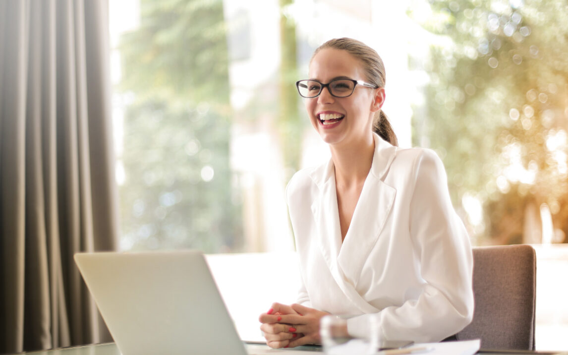woman sitting at a desk and laughing, SAP Business Technology Platform (SAP BTP)