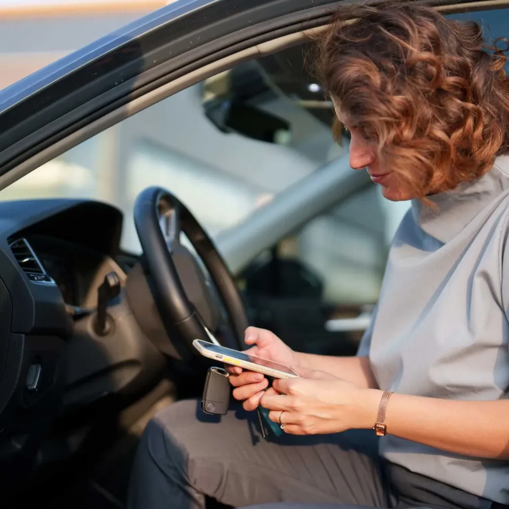 healthcare workers using mobile phone in her car