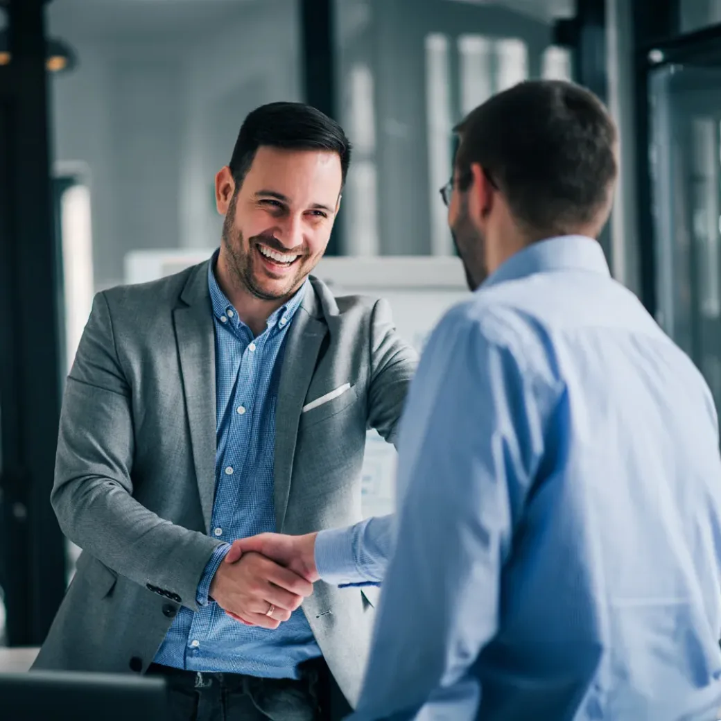 Portrait of cheerful young manager handshake with employee.