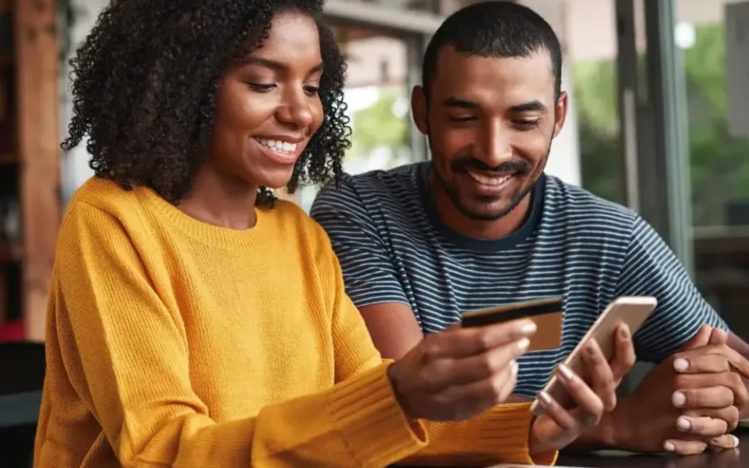 In a café, a couple pay for their order with a credit card and enjoy the atmosphere.