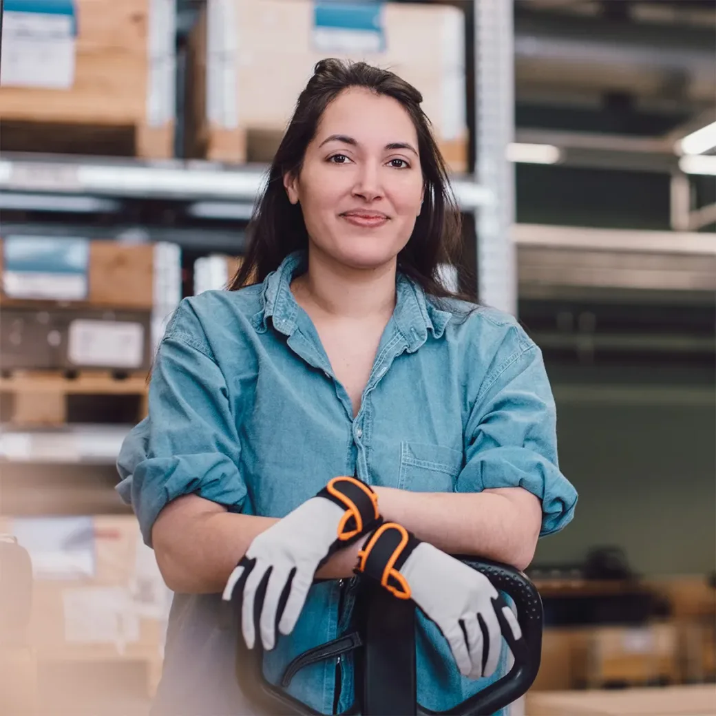 Portrait of young worker leaning on pallet jack at warehouse