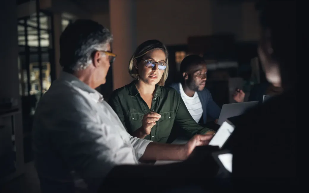 Shot of a group of colleagues having a meeting during a late night in a modern office