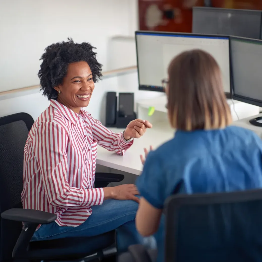 Two female coworkers consulting together in the office working on the project