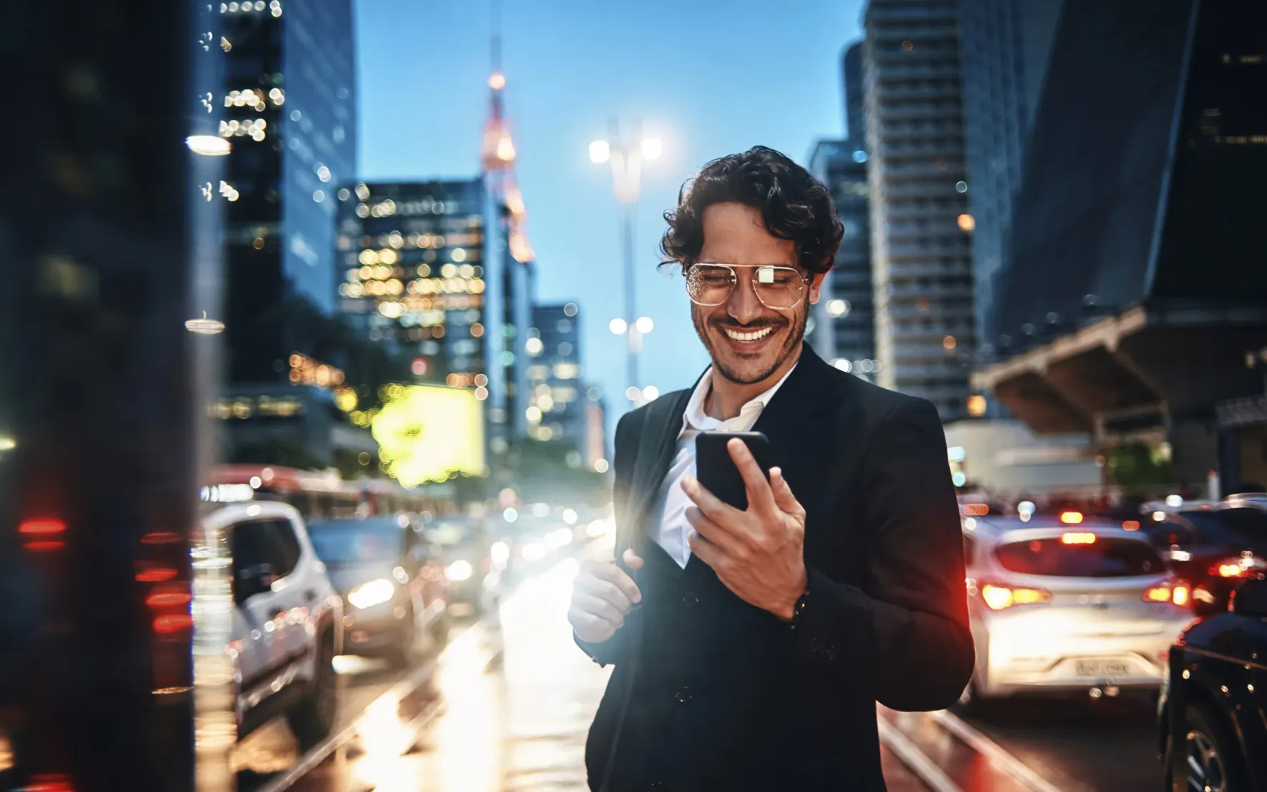 Lächelnder Geschäftsmann mit einem Handy in der Hand, Hintergrund Skyline einer Stadt | Agentic AI