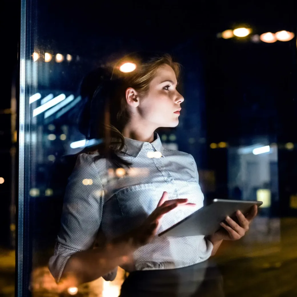 Frau am Tablet, schaut dabei aus dem Fenster | SAP BW/4HANA | SAP Analytics